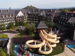 Karpacz hotel z aquaparkiem oferuje zjeżdżalnie i baseny. Widać też góry w tle.