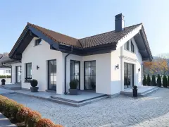 Nowoczesny projekt elewacji białego domu z ciemnym dachem i oknami. Elegancka przestrzeń wokół z kostki brukowej i zieleni.