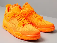 Un paio di scarpe Jordan 4 arancioni brillanti, con tomaia in maglia e dettagli iconici.