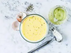 Zutaten für eine cremige french dressing: Eierschalen, Pfeffer, Öl und eine Schüssel mit der fertigen Soße.