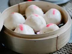 Pierożki baozi w bambusowym parowniku, gotowe do podania.
