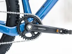 Jak odkręcić pedały w rowerze? Widok na korbę Shimano, łańcuch i fragment ramy roweru.
