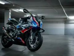 Sportowy motocykl BMW XR w barwach M, z niebieskimi światłami LED, gotowy do jazdy po torze.