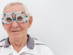 Anziano con occhiali da prova per esame della vista, controlla la vista per prevenire l'invecchiamento precoce della retina.