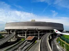 Charakterystyczny Terminal 1 na lotniskach w Paryżu, z krętymi drogami i skrzydłem samolotu.
