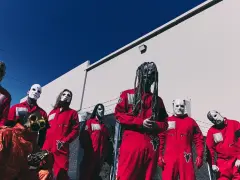 Zespół Slipknot w czerwonych kombinezonach i maskach, gotowy na premierę **slipknot new album**.