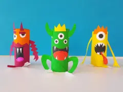 Trois monstres colorés faits à la main, en rouleaux de papier toilette, sur fond bleu.