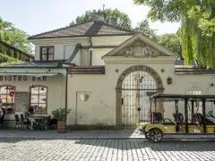 Kazimierz, Kraków. Bistro Bar i zabytkowa brama z hebrajskimi napisami. Obok żółty meleks, idealny na zwiedzanie.