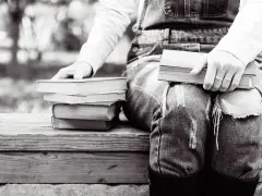 Persona sentada con varios libros en francés fáciles de leer, listos para una tarde de lectura.