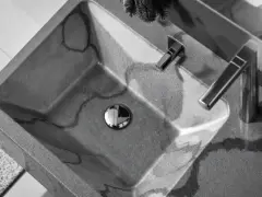Évier en béton gris avec des veines sombres, robinetterie moderne. La différence évier lavabo est subtile, mais ici, c'est un lavabo design.