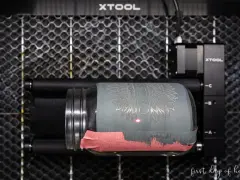 Laser engraving a jar with tempera paint. The laser is creating a sunflower design on the painted glass.