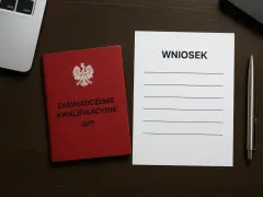 Czerwona książeczka z orłem i napisem "Zaświadczenie Kwalifikacyjne UDT" obok formularza "Wniosek" i długopisu. Przygotowanie do przedłużenia uprawnień UDT.