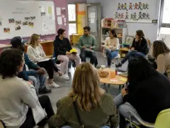 Des participants échangent lors d'une formation, peut-être des stages BAFA, dans une salle colorée.