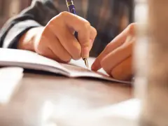 Dłoń pisze piórem na dokumencie, być może podpisując poręczenie na wekslu.