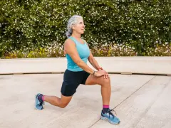 Femme âgée faisant un étirement des jambes, préparation pour un échauffement pieds randonnée.