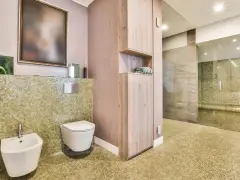 Salle de bain moderne avec bidet et WC suspendu. L'inconvénient du WC suspendu est l'accès au réservoir, caché derrière le mur.