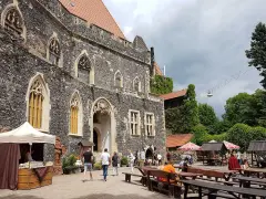 Kamienny zamek Grodziec z gotyckimi oknami, dziedziniec z kramami i ławami. Wiele osób zwiedza to miejsce, a opinie o zamku Grodziec są pozytywne.