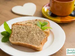 Zwei Scheiben saftiger Becherkuchen mit Joghurt, garniert mit Minze, neben einer Tasse Kaffee.
