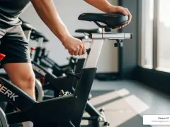 A person adjusts the seat on a spin bike, ready for an intense spin class.