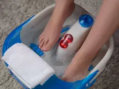 Pieds dans un bain à bulles, profitant d'un moment de détente pour la beauté des pieds. Une serviette blanche est à portée de main.