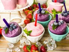Erfrischendes Eis in Schalen, perfekt zum **Crème double selber machen**. Blaubeeren und Erdbeeren garnieren die bunten Leckereien.
