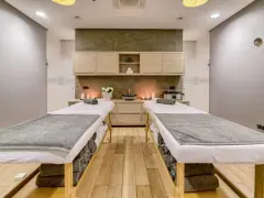 Dwie leżanki do masażu, świece i kwiaty tworzą atmosferę relaksu. Idealne miejsce na 2-dniowy pobyt w spa dla dwojga.