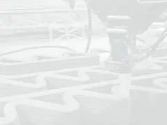 Robot buduje ściany metodą druku 3D. Warstwy betonu tworzą falisty wzór, zapowiadając przyszłe budowle.
