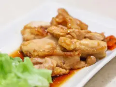 Straccetti di pollo succulenti in salsa agrodolce, serviti con insalata fresca e carote.