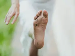 Pie sucio y descalzo, con tierra y hierba. Un consejo para como quitar el olor de los pies es lavarlos bien.