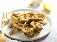 Carciofi cotti in olio e limone, pronti per essere serviti. Scopri come congelare i carciofi per averli sempre a disposizione.