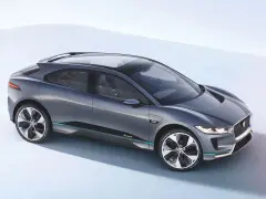 Elegancki, szary Jaguar I-PACE, niczym czarny jaguar gotowy do skoku, prezentuje swoją aerodynamiczną sylwetkę na jasnym tle.
