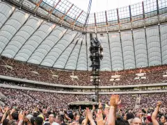 Roztanczony PGE Narodowy w Warszawie, tłumy ludzi na koncercie pod dachem stadionu.