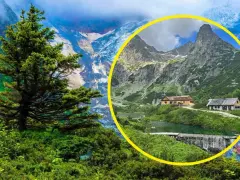 Malownicze jezioro w dolinie Rybiego Potoku, otoczone zielenią i górami, z chatkami turystycznymi.