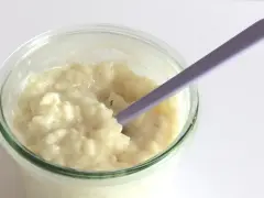 Budino cremoso, profumato alla vaniglia, come quello della ricetta della nonna, pronto per essere gustato con un cucchiaino viola.