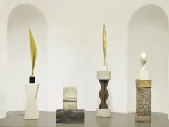 Rzeźby inspirowane twórczością **Constantin Brâncuși**: złoty liść, kamienna postać, drewniany rdzeń i biała głowa.