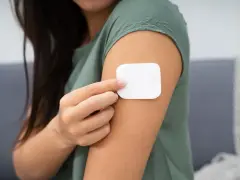 Kobieta przykleja plaster antykoncepcyjny. Przed użyciem warto zapoznać się z przeciwwskazaniami.