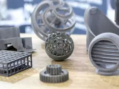 A collection of intricate 3D printing spare parts, including a lattice sphere, gears, and a vent, showcasing advanced manufacturing capabilities.