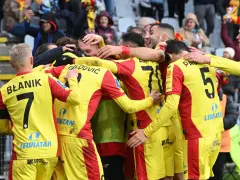 Piłkarze Korony Kielce świętują zwycięstwo nad Górnikiem Zabrze. Radość i okrzyki na boisku, kibice na trybunach.