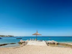 Słoneczny dzień na plaży w Simuni camping. Leżaki pod parasolem, dmuchany plac zabaw w wodzie i błękitne morze.