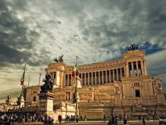 Monument imposant à Rome, sous un ciel orageux. Pensez à la fiscalité pour votre projet d'expatrier en Italie.