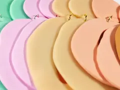 Fimolera smycken i pastellfärger, arrangerade i en mjuk kurva. Grönt, mintgrönt, rosa, beige och orange skapar en drömsk färgpalett.