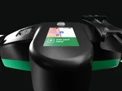 Lenkrad eines E-Scooters mit Display, das die Bolt Taxi App anzeigt. "Can park here" ist auf dem Bildschirm zu lesen.