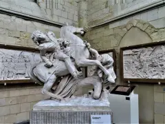 Sculpture équestre de David d'Angers, un homme en uniforme militaire sur un cheval cabré, avec des bas-reliefs en arrière-plan.