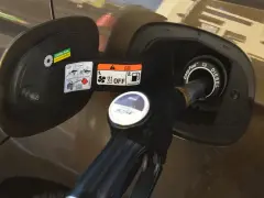 Dozbrań do baku diesla. Pistolet paliwowy wlewa paliwo do samochodu, pokazując, jak zatankować auto.