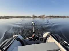 Schlauchboot mit Außenborder auf ruhigem Wasser. Die Beleuchtung des Schlauchboots entspricht der Vorschrift für sicheres Fahren.