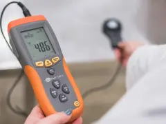 Pomiar natężenia światła za pomocą luksomierza. Urządzenie pokazuje 486 luxów.