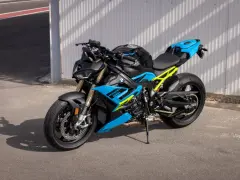 Potężny motocykl BMW S1000R w jaskrawych kolorach niebieskim i żółtym, gotowy do jazdy po torze.