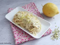 Spaghetti al limone cremosi, un piatto invitante con scorza di limone grattugiata e pistacchi tritati.