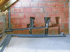 Instalacja hydrauliczna w trakcie budowy, widoczne rury kanalizacyjne i wodne. To kluczowy etap, by wiedzieć, jak zrobić odpowietrzenie WC.