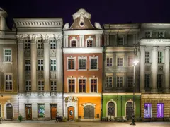 Nocny widok na kolorowe kamienice Starego Rynku w Poznaniu, przypominające urokliwe osiedle warszawskie.